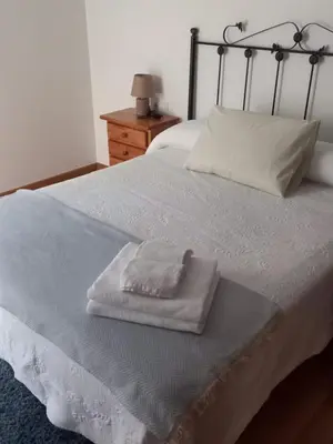 a bed with two white towels sitting on it at Piso DJC in O Pedrouzo