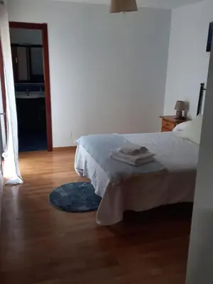 a bedroom with a bed and a wooden floor at Piso DJC in O Pedrouzo