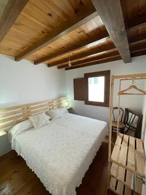 a bedroom with a bed and a wooden ceiling at Casa duples junto playa Cubelas in San Ciprián