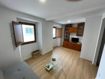 an empty living room with a table and a window at Casa duples junto playa Cubelas in San Ciprián