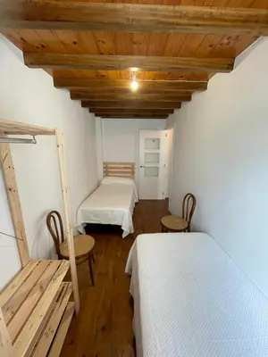 a room with two beds and wooden ceilings at Casa duples junto playa Cubelas in San Ciprián