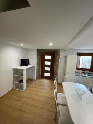 a kitchen and dining room with a white table and chairs at Casa duples junto playa Cubelas in San Ciprián