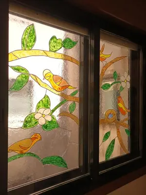 a stained glass window with birds on a branch at Fogar da Fraga in Caldas de Reis
