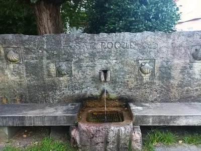 a stone bench with a water fountain on it at Fogar da Fraga in Caldas de Reis