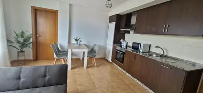 a kitchen with a table and chairs and a kitchen with a counter at Apartamento Faro Burela in Burela de Cabo