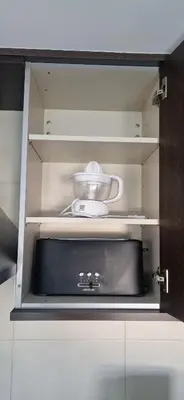 a kitchen cabinet with a bowl and a appliance in it at Apartamento Faro Burela in Burela de Cabo