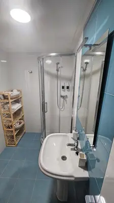 a bathroom with a white sink and a shower at Apartamento Faro Burela in Burela de Cabo