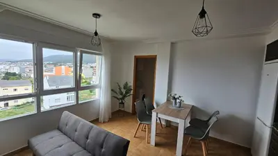 a living room with a couch and a table with chairs at Apartamento Faro Burela in Burela de Cabo
