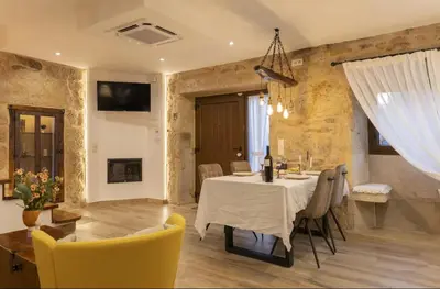 a kitchen and dining room with a table and chairs at O Fogar da Pequena Galia in Caldas de Reis