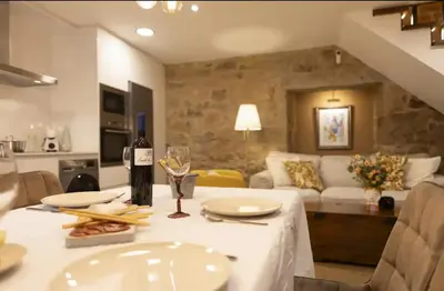 a bottle of wine sitting on a table in a living room at O Fogar da Pequena Galia in Caldas de Reis