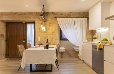 a kitchen with a table with a wine bottle on it at O Fogar da Pequena Galia in Caldas de Reis