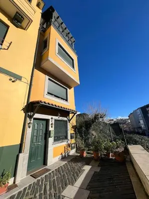 a yellow and green house with a green door at Casa con terraza en el casco in Betanzos