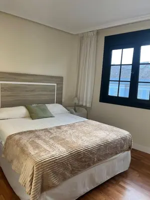a bedroom with a large bed and a window at Casa con terraza en el casco in Betanzos