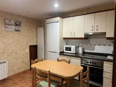 a kitchen with a wooden table and a microwave at Casa con terraza en el casco in Betanzos