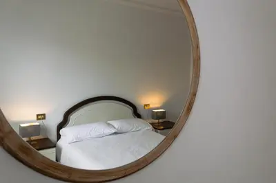 a bedroom with a bed in a round mirror at Braida Ribeira Sacra in Sober