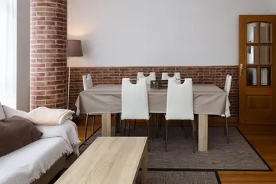 a dining room with a table and white chairs at Braida Ribeira Sacra in Sober
