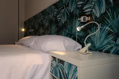 a bedroom with a bed with a tropical wallpaper at Braida Ribeira Sacra in Sober
