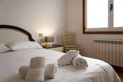 a bedroom with a white bed with towels on it at Braida Ribeira Sacra in Sober