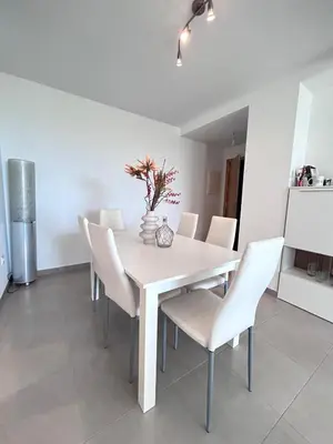 a white dining room with a white table and chairs at S&H La Gaita in Foro