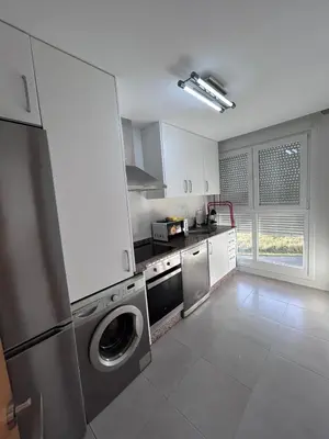 a kitchen with a washer and dryer in it at S&H La Gaita in Foro