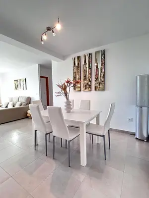 a white dining room with a white table and chairs at S&H La Gaita in Foro