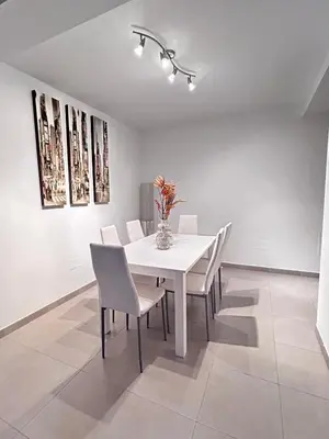 a white dining room with a white table and chairs at S&H La Gaita in Foro