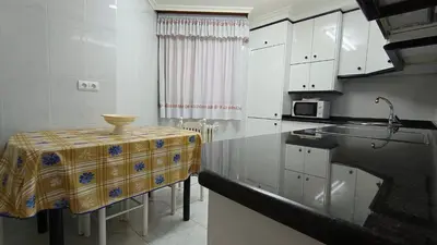 a kitchen with a table and a counter top at O Xardín Termal in Ourense