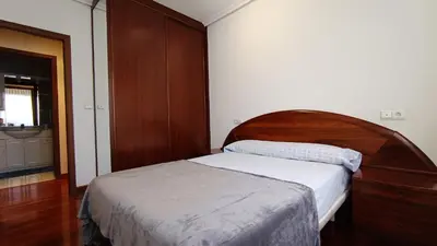 a bedroom with a bed with a wooden headboard at O Xardín Termal in Ourense
