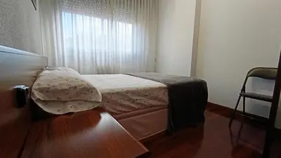 a small bedroom with a bed and a window at O Xardín Termal in Ourense
