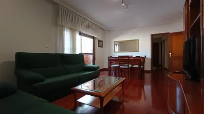 a living room with a green couch and a table at O Xardín Termal in Ourense