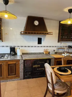 a kitchen with an oven and a clock on the wall at Casa Germán in A Coruña