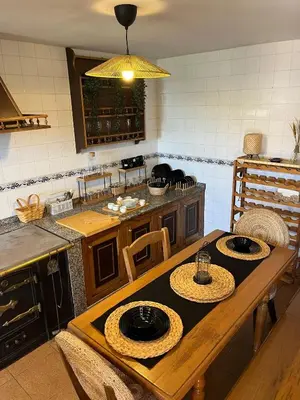 a kitchen with a wooden table with plates on it at Casa Germán in A Coruña