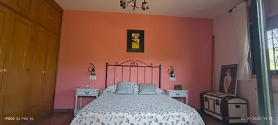 a bedroom with a bed and an orange wall at Casa Mercedes in Quiroga
