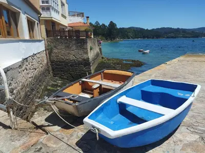 a blue boat parked next to a building next to the water at Apartamento 