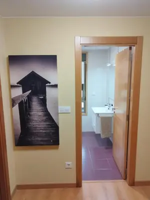 a bathroom with a painting of a pier at Apartamento 