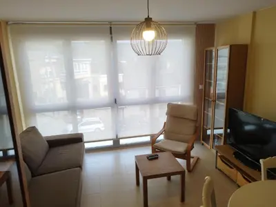 a living room with a couch and a chair and a television at Apartamento 