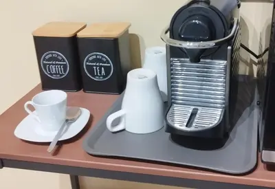 a coffee maker and cups on a table at Apartamento 