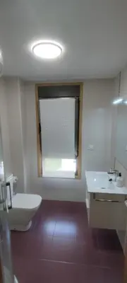 a bathroom with a toilet and a sink and a window at Apartamento 