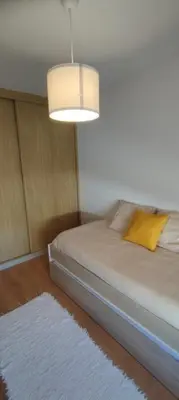 a bedroom with a bed with a lamp and a rug at Apartamento 