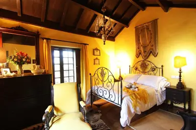 a bedroom with a bed and a chair and a window at Te Cuento 3 Xesteira in A Xesteira