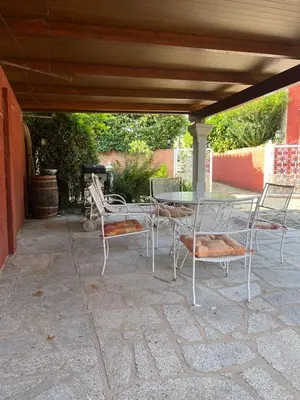 a patio with a table and chairs under a roof at Casa Romeo in Brion