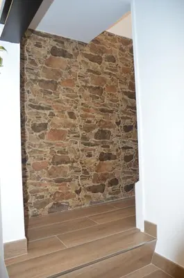 a stone wall in a hallway with a brick wall at Tras Do Atrio Casa en el Centro de Betanzos in Betanzos