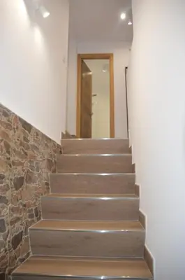a stairway with a stone wall and a door at Tras Do Atrio Casa en el Centro de Betanzos in Betanzos