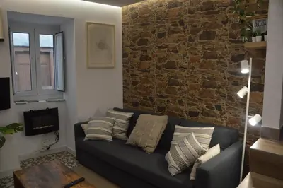 a living room with a couch and a brick wall at Tras Do Atrio Casa en el Centro de Betanzos in Betanzos