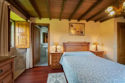 a bedroom with a bed and two night stands with lamps at Galicia in Forcarei