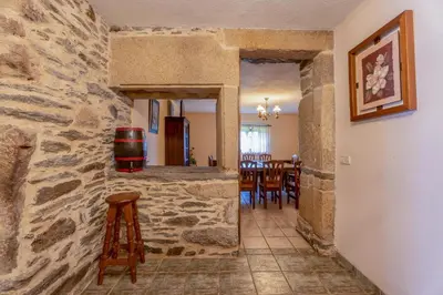 a kitchen and dining room with a stone wall at Galicia in Forcarei