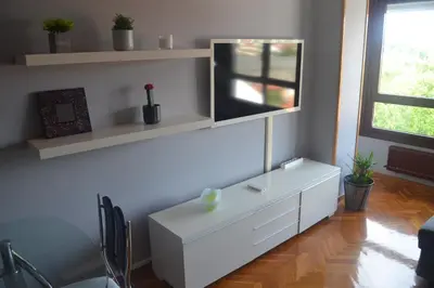 a living room with a white dresser and a tv at Lusquefusque in Monforte de Lemos
