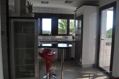 a kitchen with a table and a red stool at Lusquefusque in Monforte de Lemos