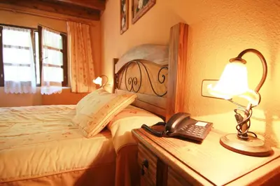 a bedroom with a bed with a lamp and a telephone at Tixileiro in Sisterna