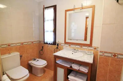a bathroom with a toilet and a sink and a mirror at Tixileiro in Sisterna